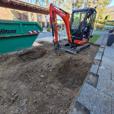 Container und Minibagger auf der Baustelle